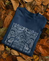 Blue sweatshirt with white geometric pattern on a bed of autumn leaves